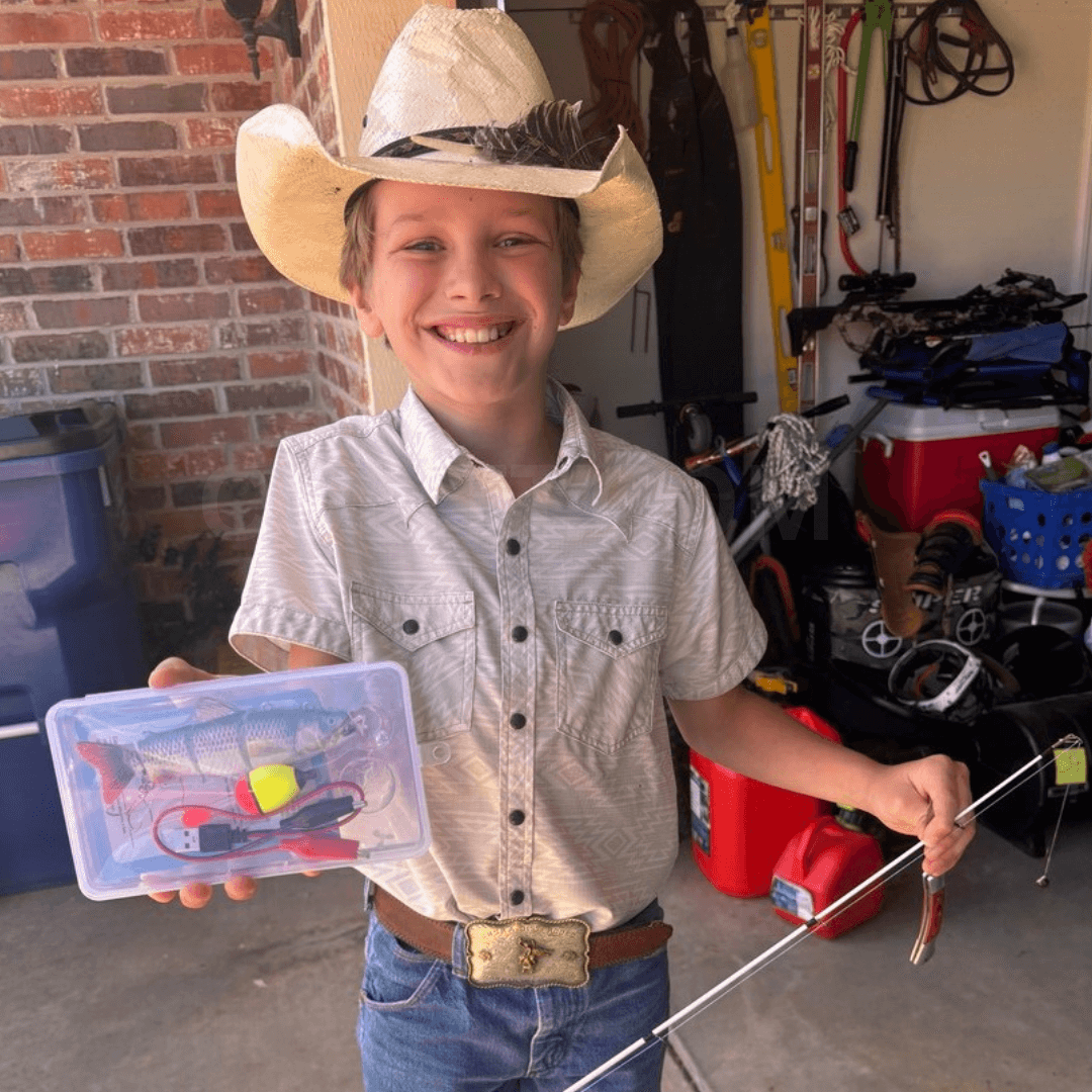 Child in cowboy hat holding a fishing kit in a garage setting